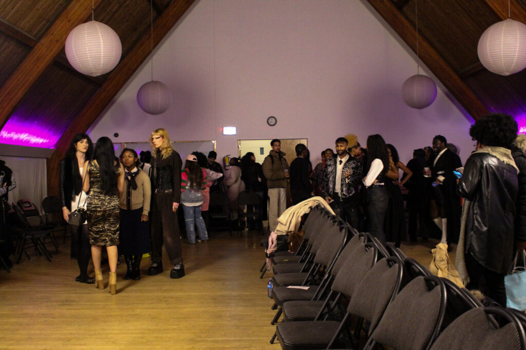 A standing crowd talks in a dimly lit room