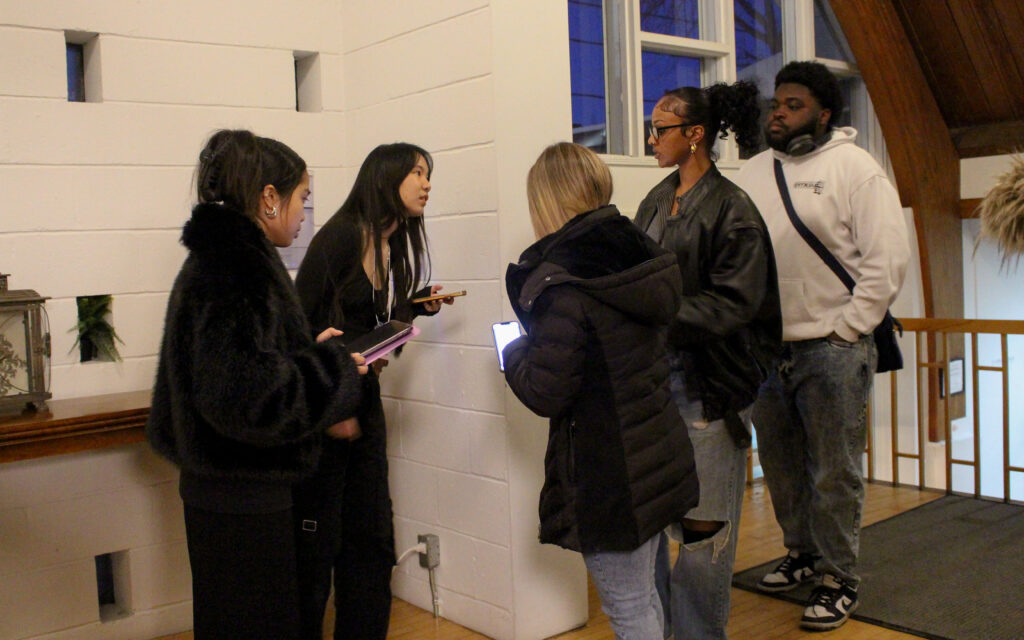 Three people line up to have their tickets scanned by two volunteers