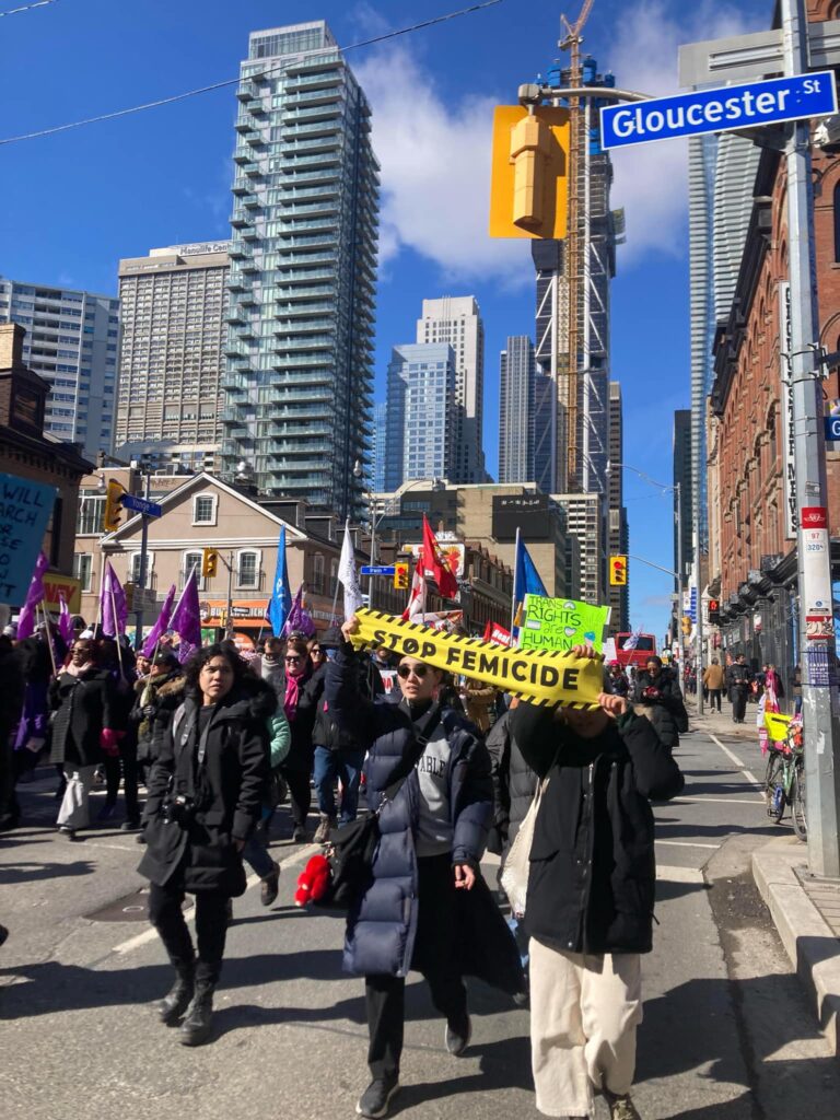 A photo of people marching down a street holding signs.