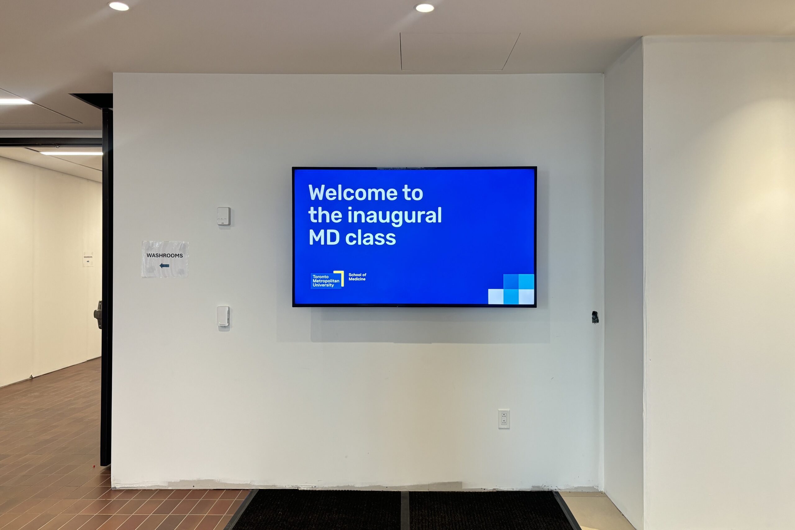 A TV inside the building welcoming the inaugural class of TMU's new School of Medicine.