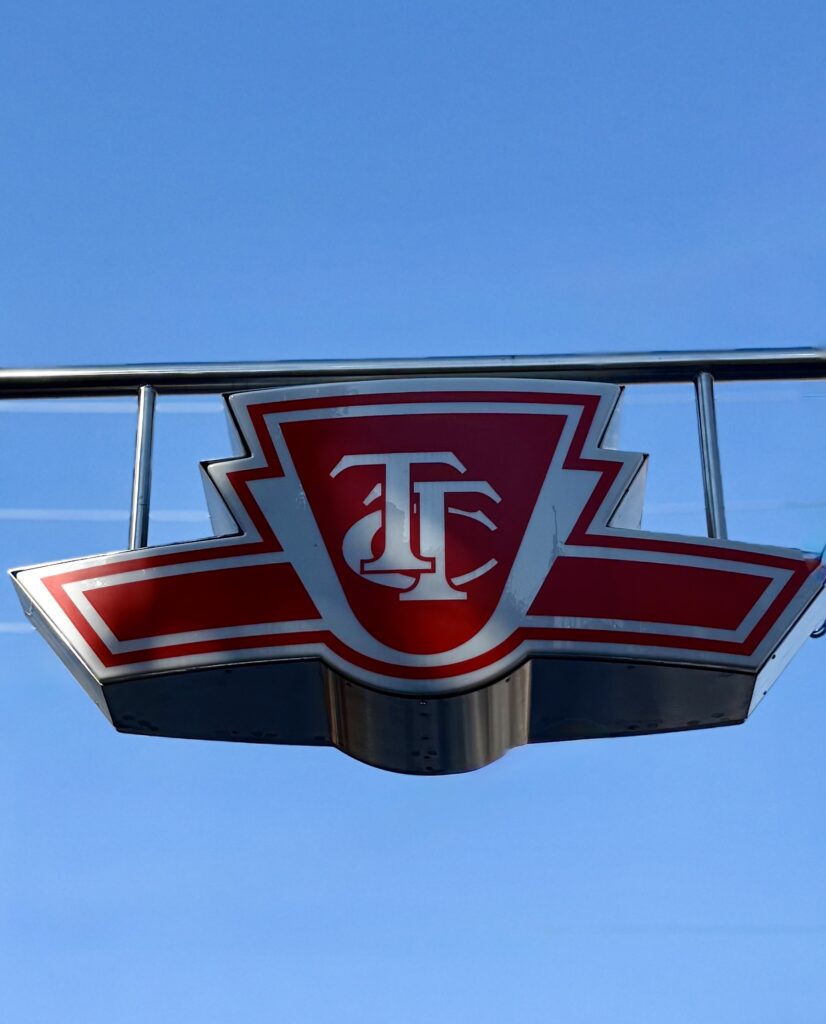 A red and white Toronto Transit Commission (TTC) logo sign