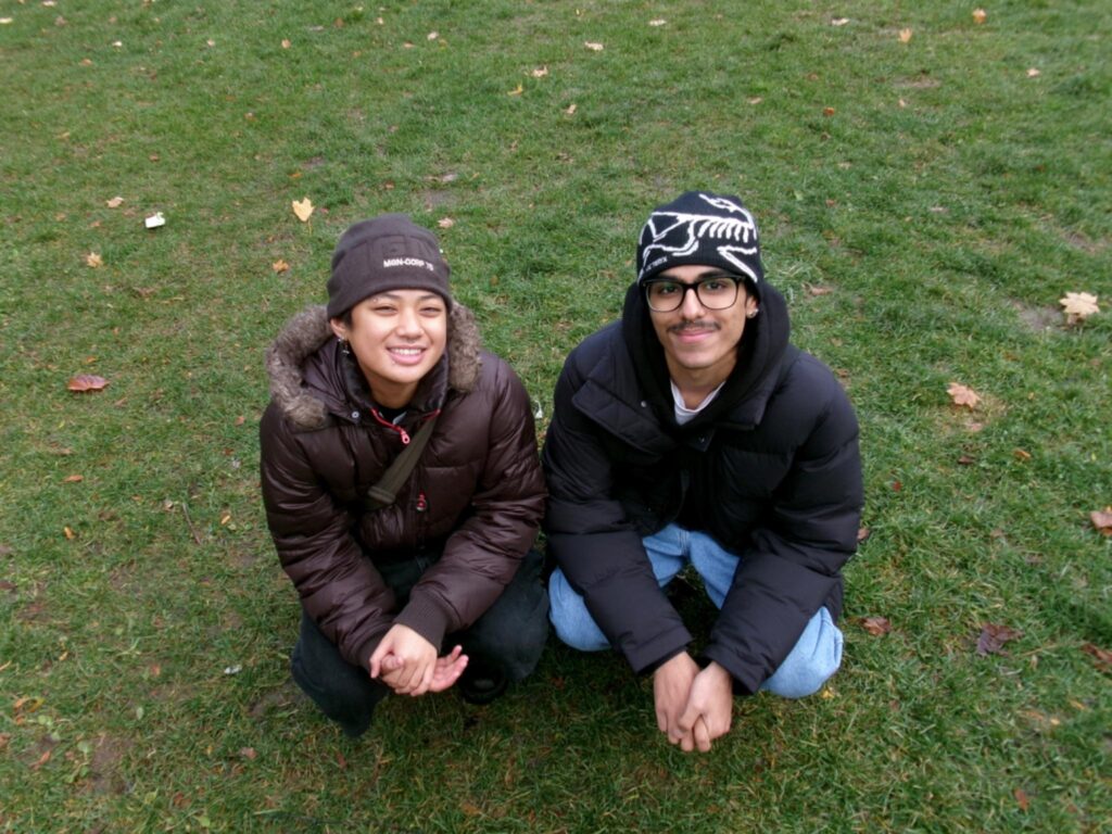 Two people kneeling on a grass field