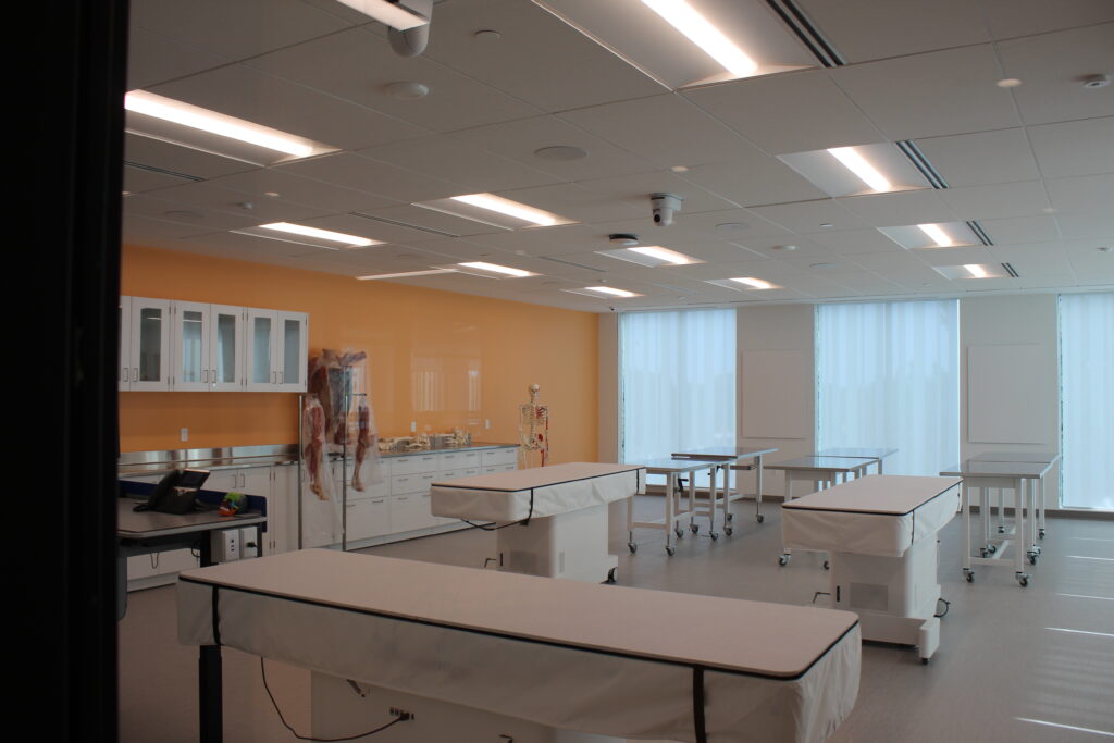 A classroom featuring medical examination tables and body dummies. 