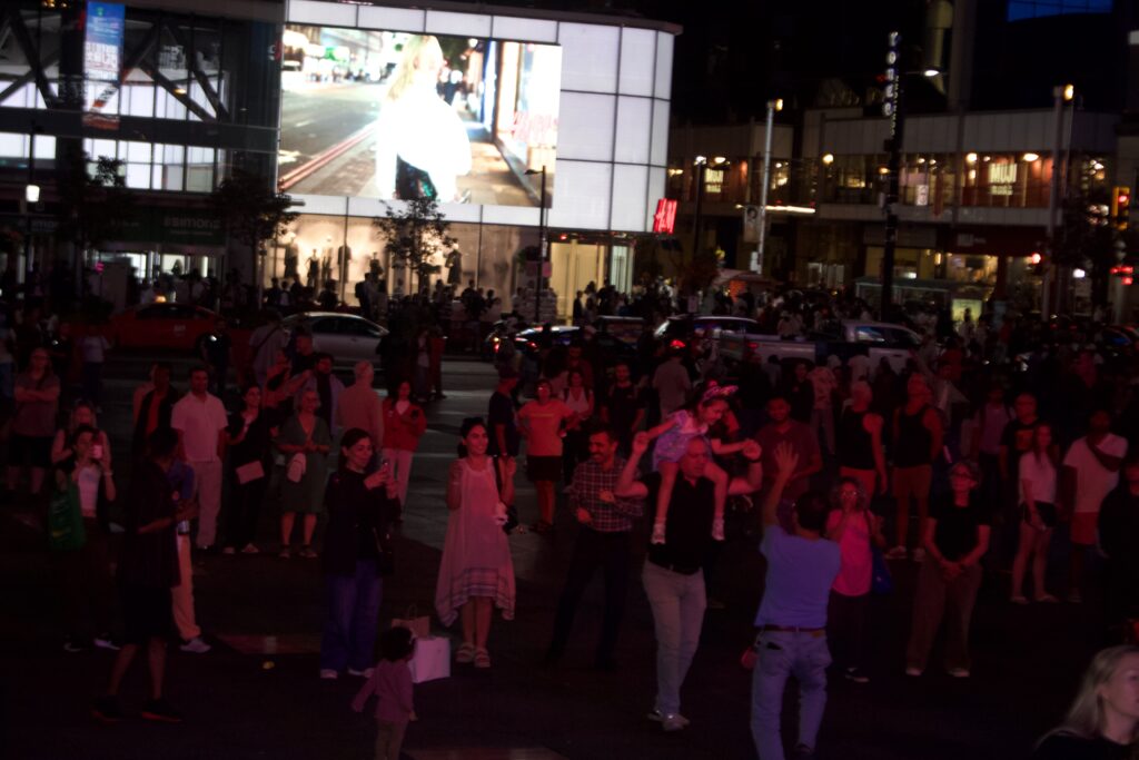 A group of people dancing and standing around at Sankofa Square for a Nuit Blanche installation.