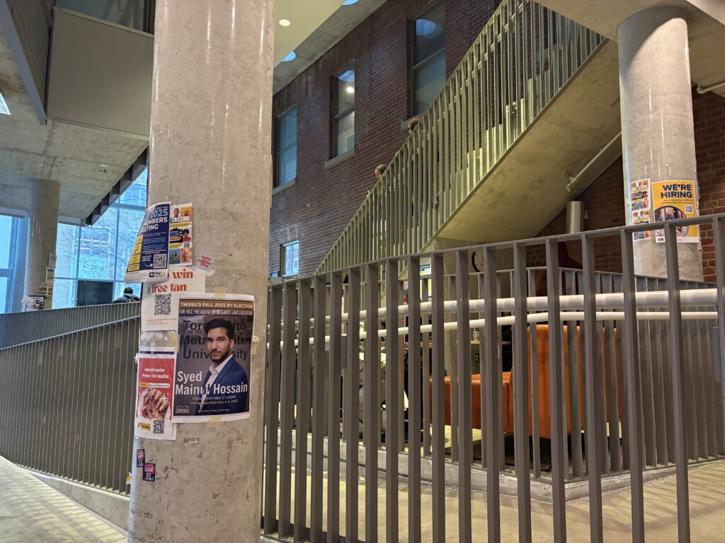 Poster taped to pillar in front of staircase
