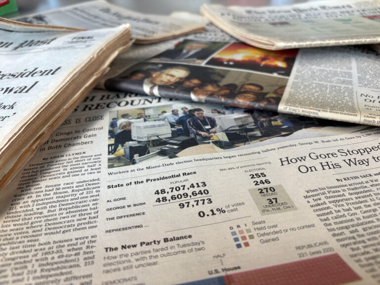 A photo of stacked newspapers on a table.