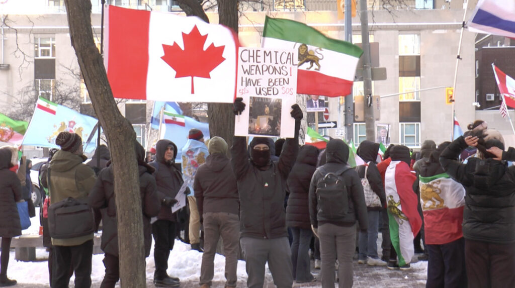 People gathered in front of U.S. Consulate holding up signs