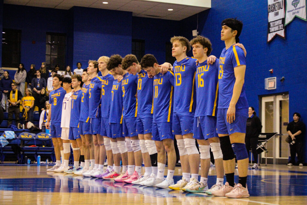 A men's volleyball team standing side by side.