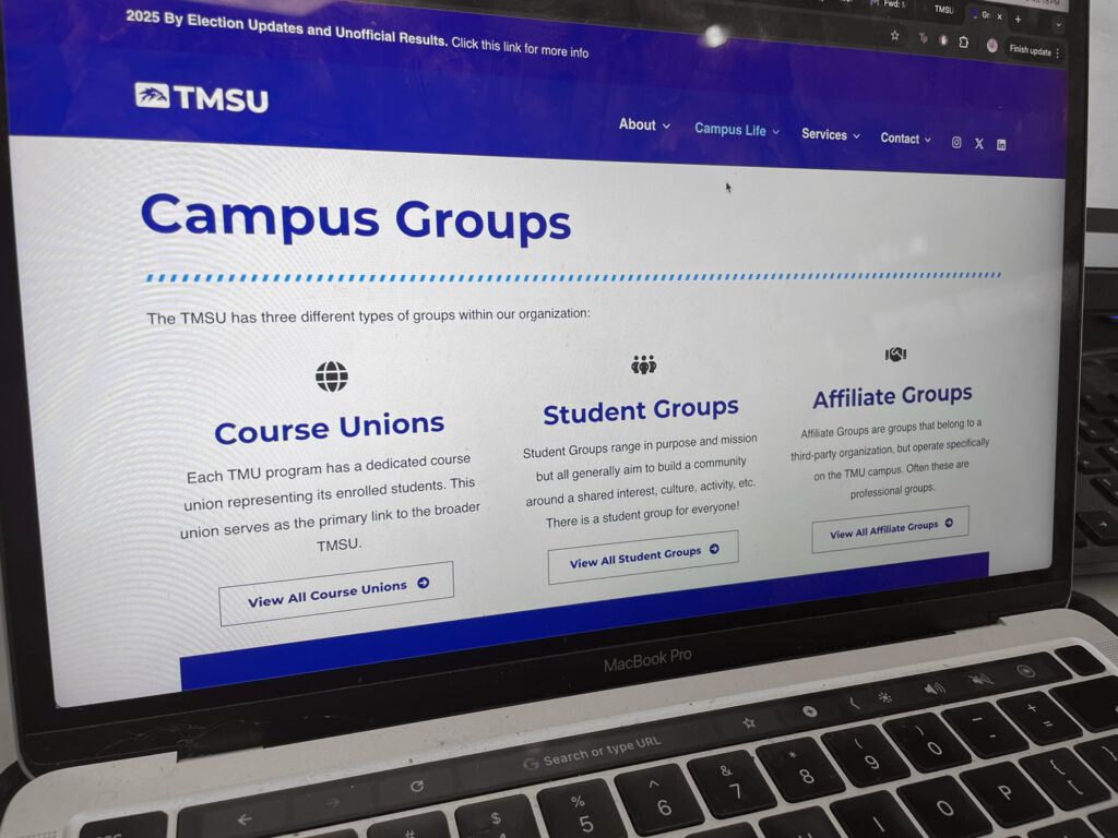 A laptop screen showing a primarily blue and while website with course unions, student groups and affiliate groups on it.