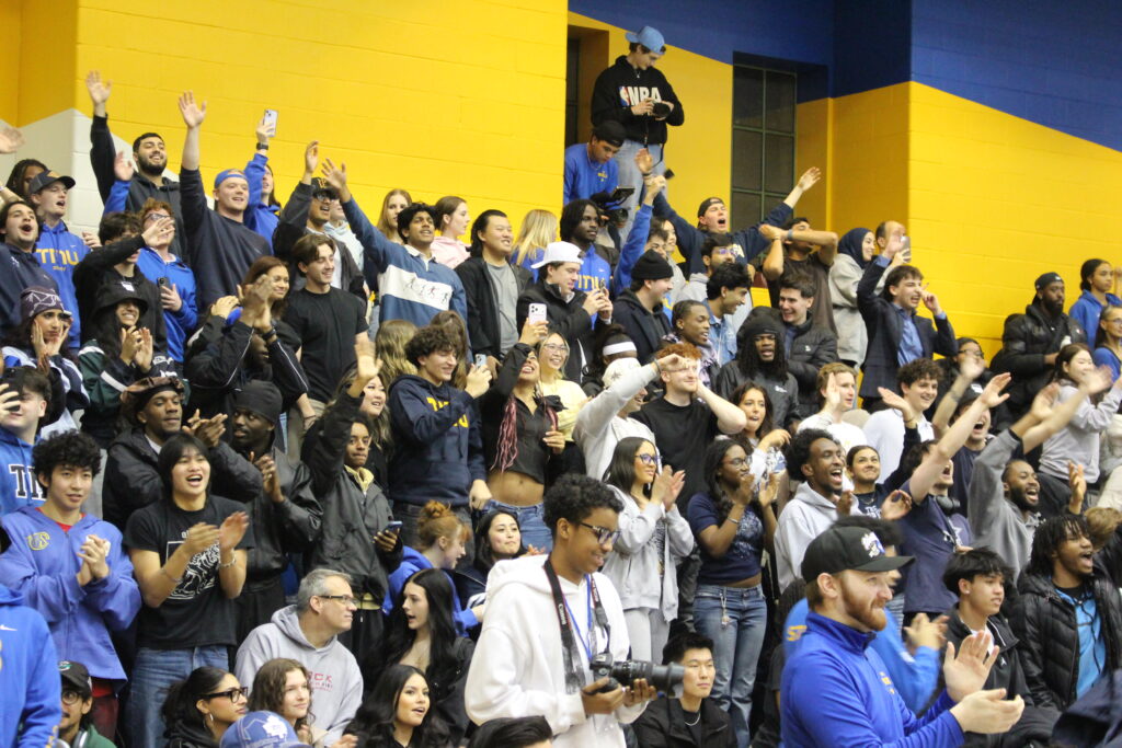 A crowd at the end of a basketball game.