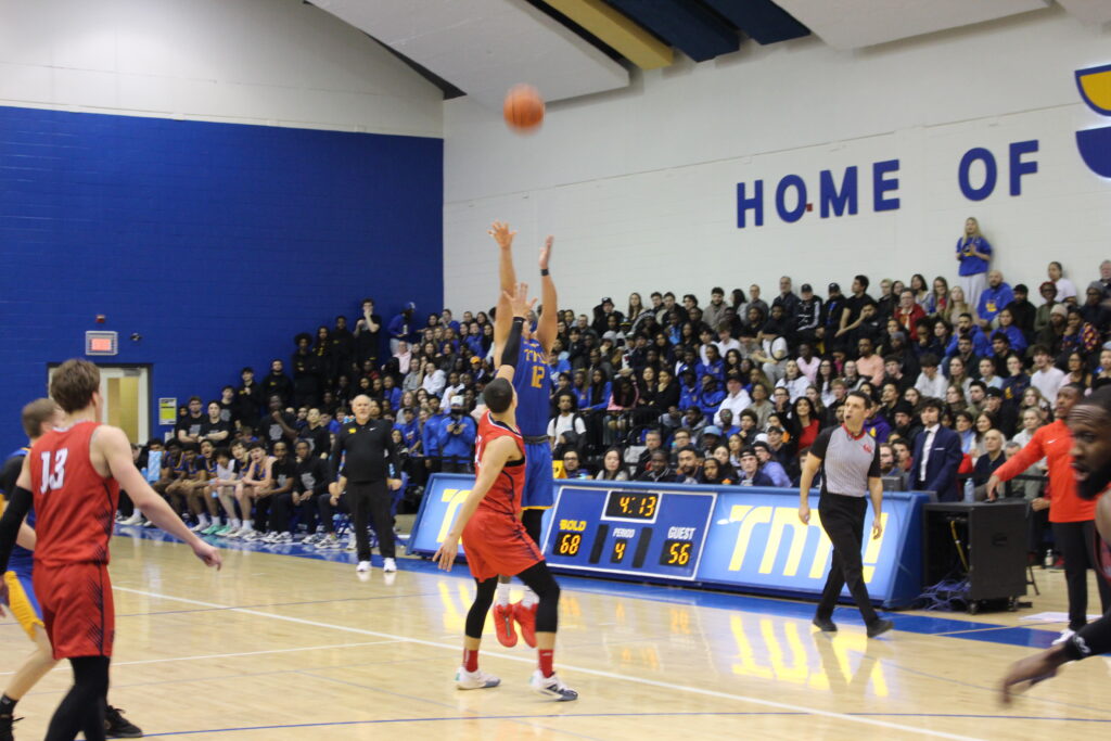 A basketball player takes a jumpshot during a game.