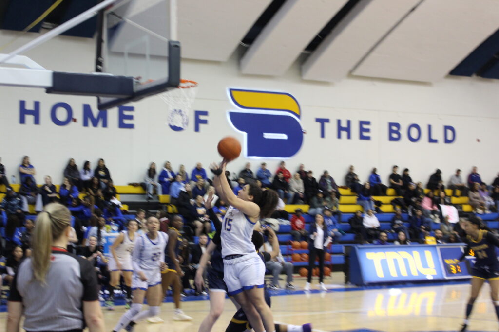 A basketball player attempts to shoot the ball.