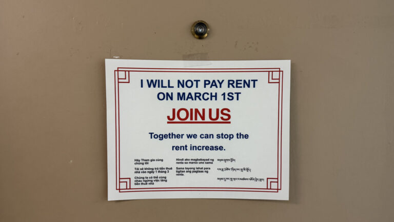 A photo of a door with a white sign.