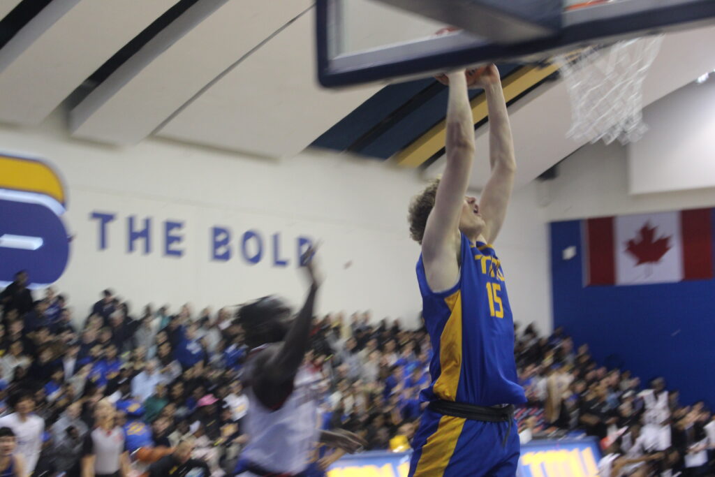 A basketball player attempts a dunk. 