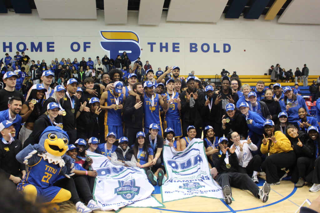 Two basketball teams pose for a photo.