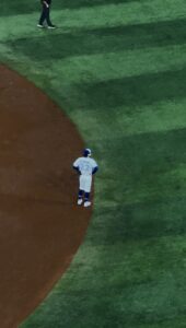 Baseball player standing with his hands on his hips 