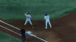 Two baseball players standing by first base 