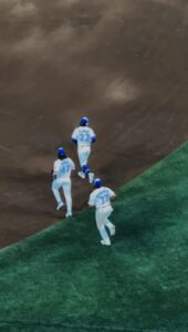 Three baseball players running on a baseball field. 