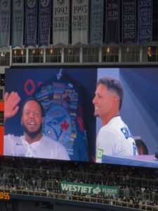Two baseball players being displayed on LED screen, one waving 