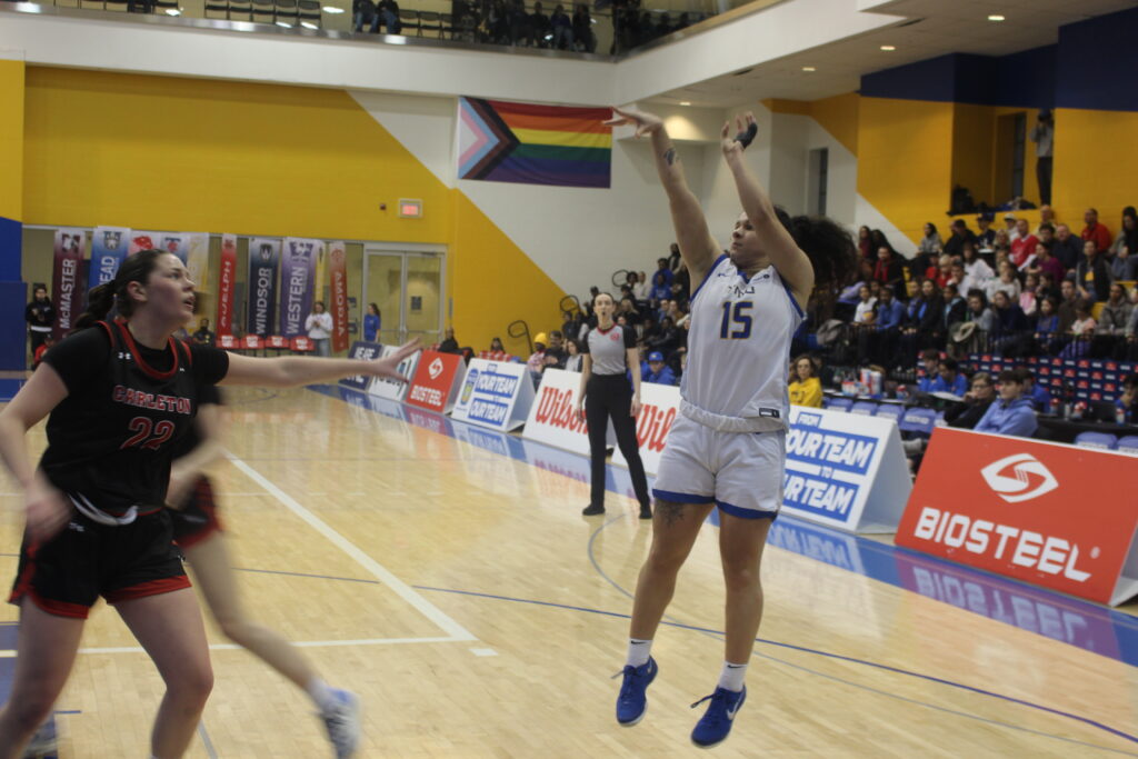 A basketball player takes a jumpshot during a game.