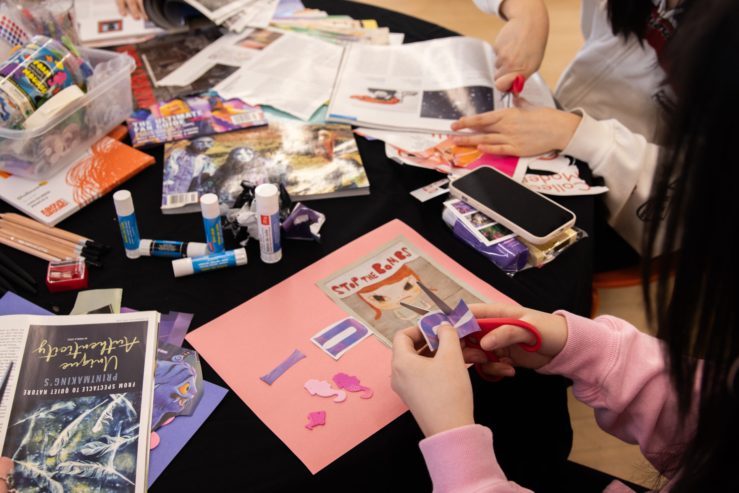 A student cuts out letters for a collage.