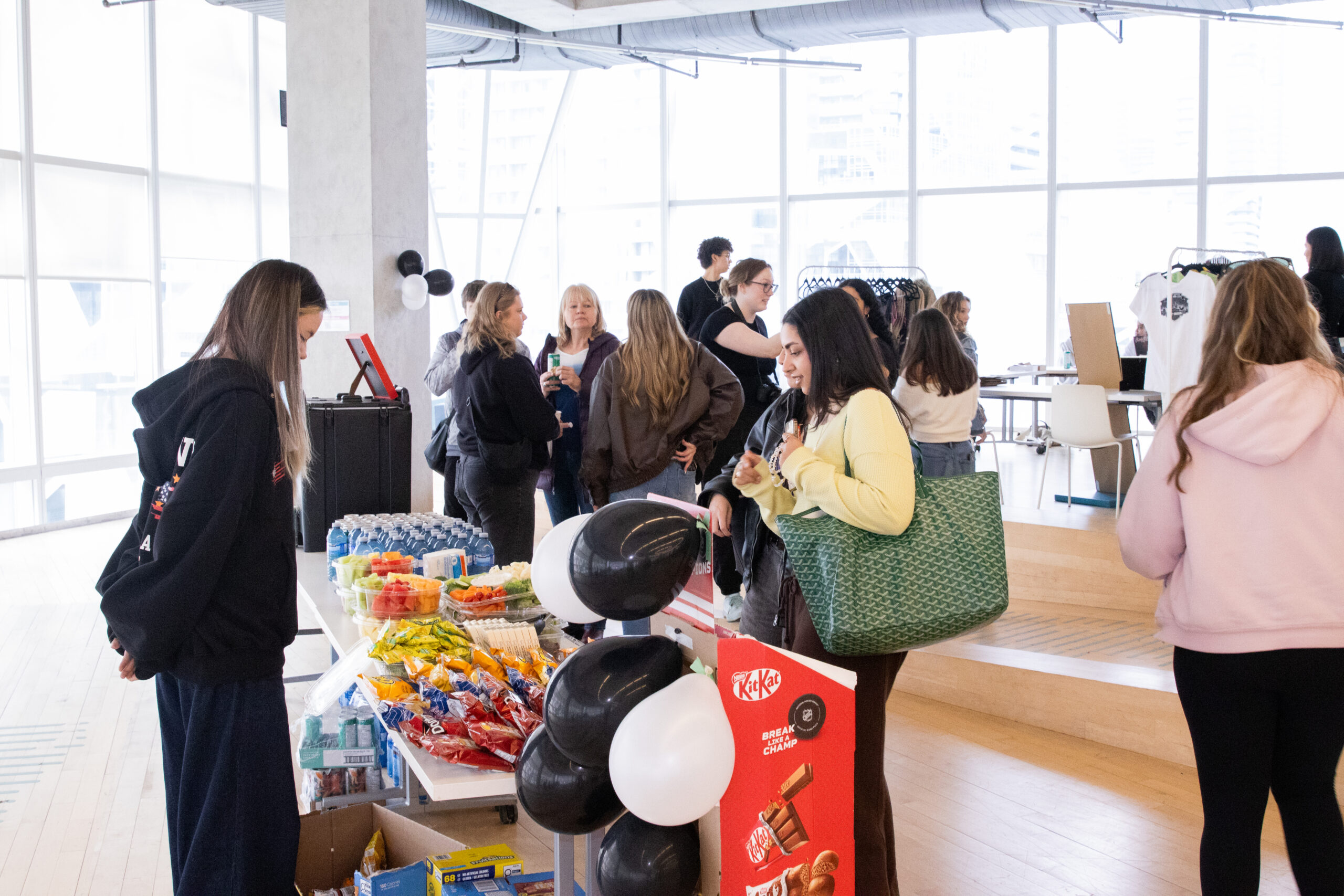 Students gathering around food and drinks table.