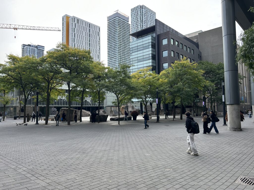 Students walk through Toronto Metropolitan University's campus with buildings visible in the background.