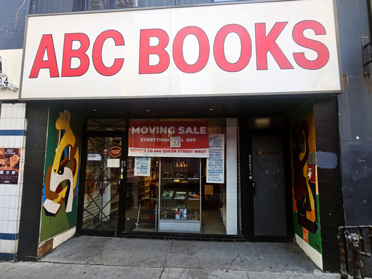 The entrance of a small bookstore with its name written in big, red, block letters on a white mosaic.