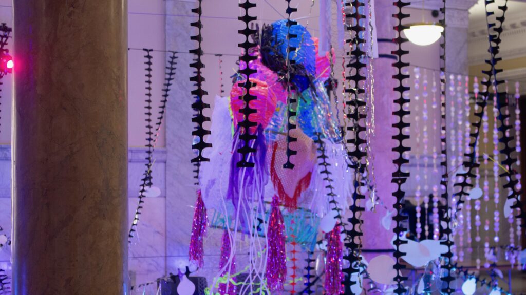 An art work surrounded by streamers and lights.