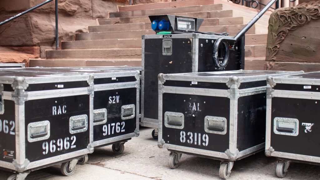 An image with five storages boxes in front of a stair case