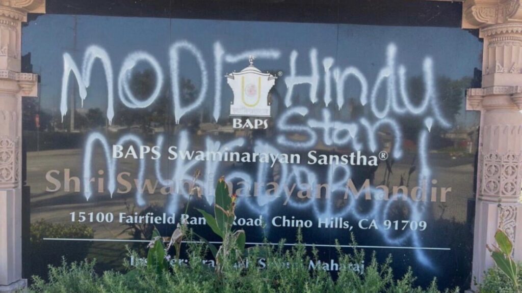Graffiti is written on glass window of a Hindu temple.