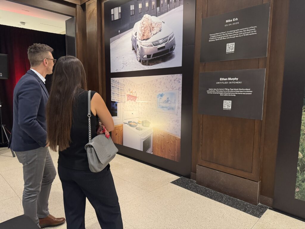Two attendees looking at Ethan’s photograph (OTR/Mostafa Al-A’sar)