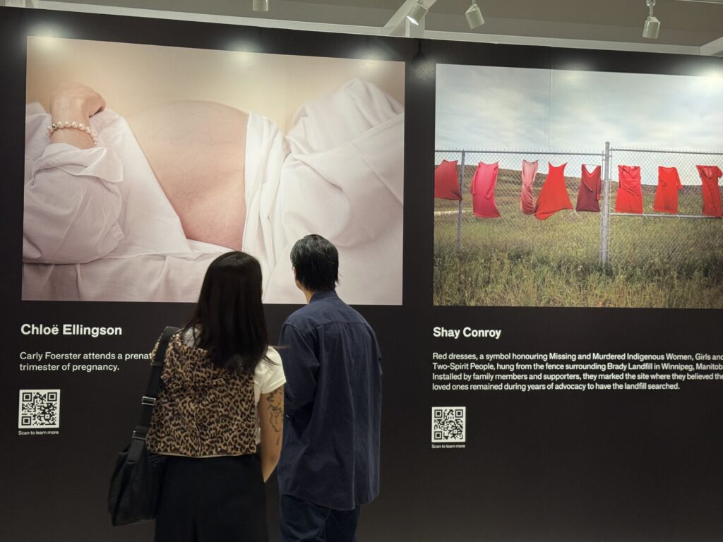 Two attendees looking at Chloë’s photograph (OTR/Mostafa Al-A’sar)