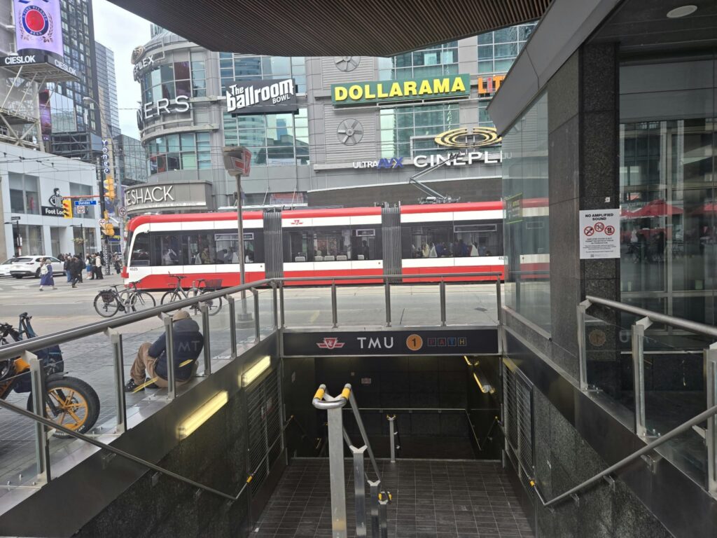 The entrance to TMU Station at Yonge and Dundas streets, with a TTC streetcar in the background.