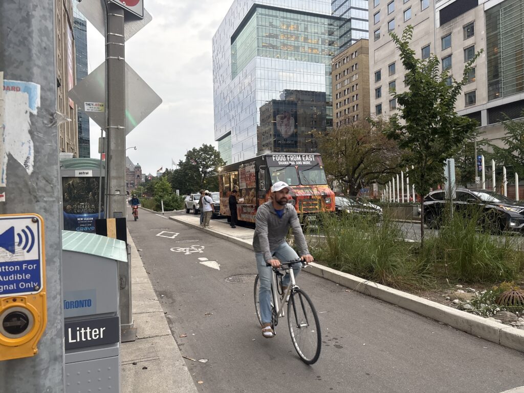 Bikers cycling in a bike lane on a busy street.