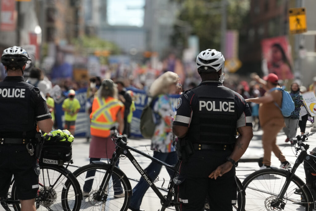 Police with bikes blocking a road for a march. They are in front of protest in downtown Toronto